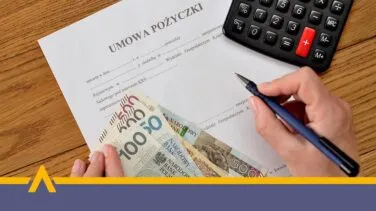 Ręce osoby podpisującej umowę pożyczki z kalkulatorem i gotówką na stole